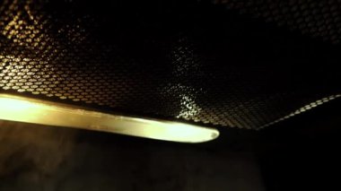 The operation of the kitchen hood in the dark. The smoke is drawn in.