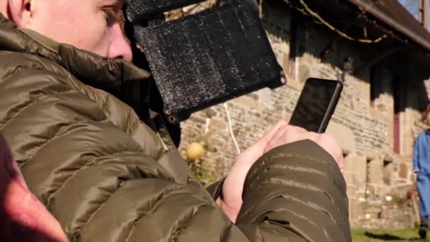Przenośna Bateria Słoneczna Drzewie Mężczyzna Pisze Sms Przez Telefon Relaksuje — Wideo stockowe