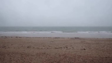 Deserted ocean coast in cloudy gloomy weather. Cold season.