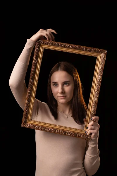 一个年轻的女人拿着一个相框 黑色背景 心理画像 反思概念 — 图库照片