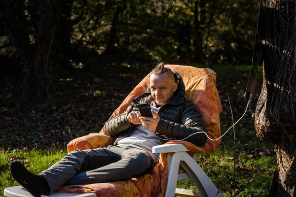 Portable Solar Battery Hanging Tree Man Resting Nature Mobile Phone — Foto Stock
