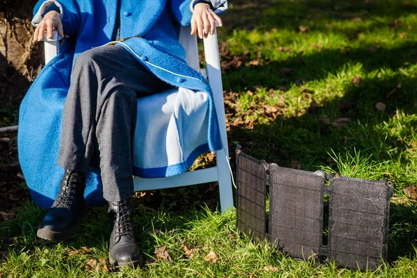 Unrecognizable Woman Sits Nature Green Grass Portable Solar Battery — Stok fotoğraf