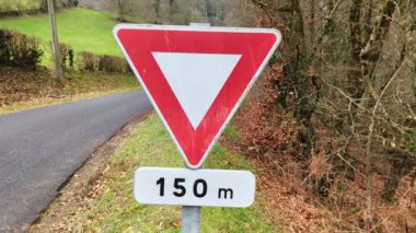 Yol tabelası yol verdi. Kırmızı üçgen, ana yolu geçmekle ilgili bir uyarı işareti..