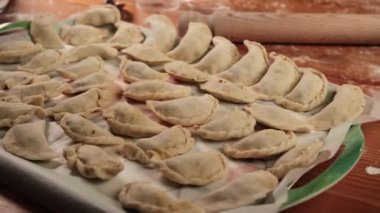 Mutfak masasında hazır hamur tatlısı. Elle yontulmuş hamur köfteleri un serpilmiş bir yüzeye serpilmiştir..