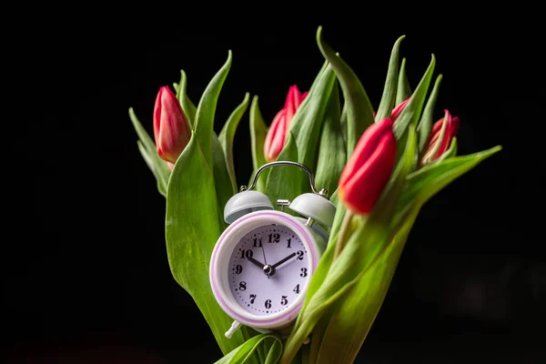 Kytice Tulipánů Budíkem Černém Pozadí Dát Čas Koncept Příchodu Jara — Stock fotografie