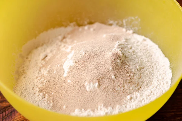 小麦粉と乾燥酵母 パンやピザ用生地の準備 急冷作用の粒状酵母をふるいにかけた小麦粉で撹拌する — ストック写真