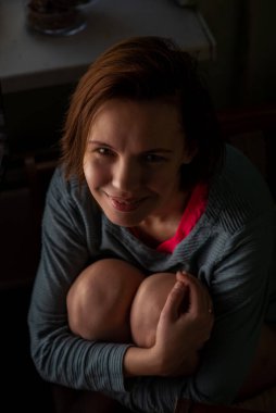 Mutlu, orta yaşlı bir kadın, 40 yaşında. Makyajsız sıradan bir kadın..