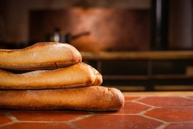 Mutfak masasında üç Fransız ekmeği. Metin için yer.