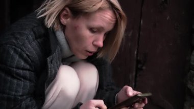 Kafası karışmış bir kadın cep telefonuna mesaj yazıyor. Orta yaşlı kadın.