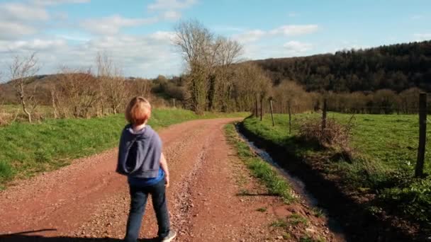Ένα Αγόρι Περπατά Κατά Μήκος Ενός Δρόμου Στην Ύπαιθρο Ενεργή — Αρχείο Βίντεο