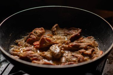 Tavada pişmiş tavşan. Tavşan soğan ve havuçla pişirilir..