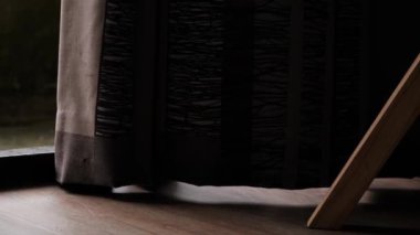 Perde odada rüzgarda dalgalanıyor. Yerde sallanan ağır bir perdenin yakın çekimi..