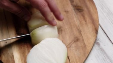 Soğanlar tahta kesme tahtasıyla kesilir. Yemek hazırlığı.