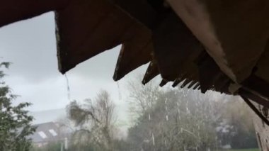 Çatının kenarından yağmur damlıyor. Kötü hava, sağanak yağmur. Kırsal.