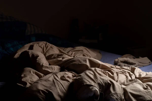 Empty Unmade Bed Dark Crumpled Blanket Lit Lamp — Foto Stock