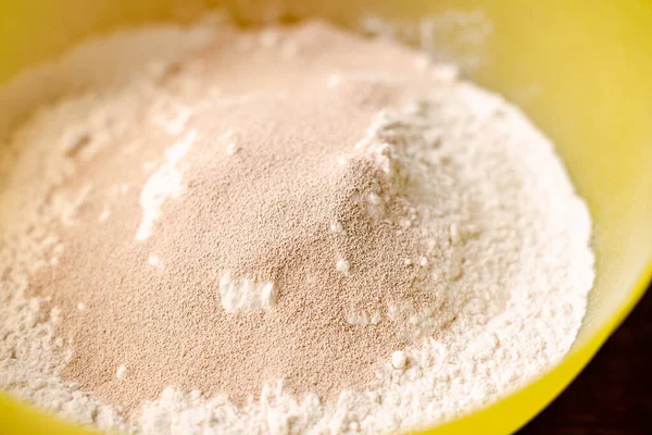 小麦粉と乾燥酵母 パンやピザ用生地の準備 急冷作用の粒状酵母をふるいにかけた小麦粉で撹拌する — ストック写真