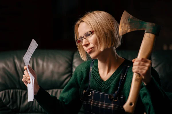 Bad news in a letter. A woman in a rage holds a letter and an ax in her hands. Bad news.