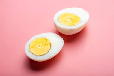 Pembe arka planda dilimlenmiş haşlanmış tavuk yumurtası..