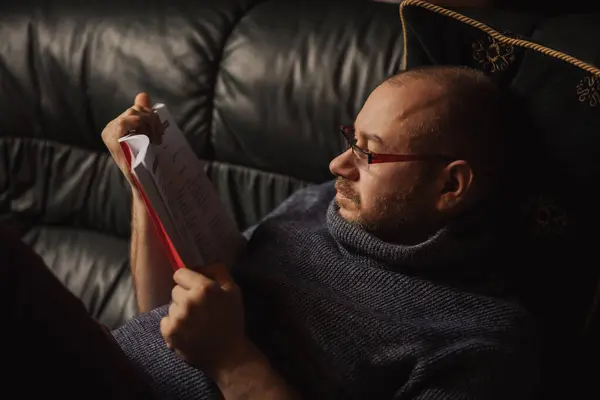 Homem Com Óculos Está Lendo Livro Enquanto Está Deitado Sofá — Fotografia de Stock