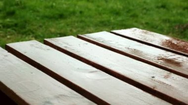 Yağmur damlaları dışarıdaki tahta masaya düşer..