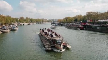 PARIS, FRANCE, -15 Nisan 2023: Güneşli bir günde Paris 'te Seine nehrinde eğlence gemisi yelken açar.