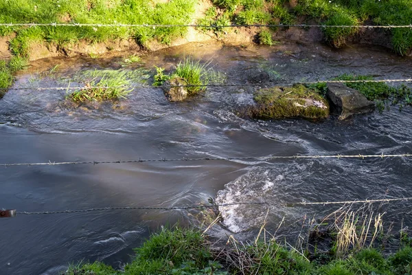 The stream is fenced with barbed wire. Protection of water resources. Private property.