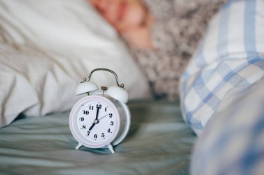 Yatağın üzerindeki çalar saat. Sabahın yedisinde. Erken kalkarım. Circadian ritim kavramı.