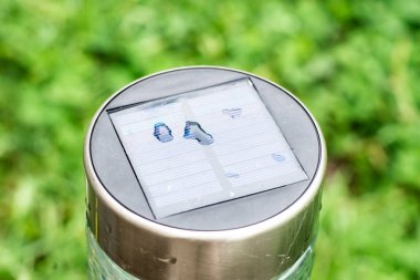 Yeşil yeşillik arka planda güneş enerjili bahçe feneri. Ekolojik enerji, bahçe dekorasyonu.