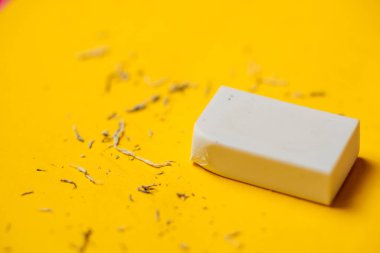 Sarı arka planda beyaz silgi. Silindikten sonra çöp..