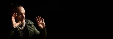 El hareketi inkar. Zayıf bir adam ellerini kaldırdı. Banner, mesaj için yer. Siyah arkaplan.