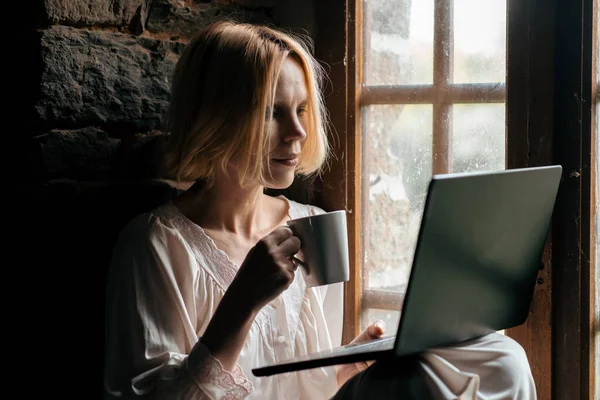 Женщина Ноутбуком Чашкой Кофе Окна Женщина Средних Лет Белой Рубашке — стоковое фото