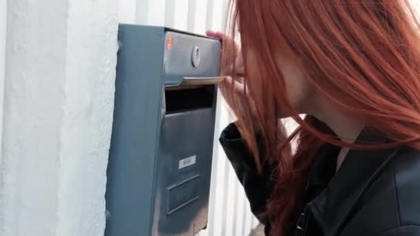 一个年轻的女人看了看信箱 检查街上的信箱 红头发的女人 — 图库视频影像