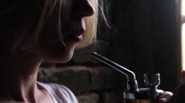 Bir kadın cihaz kullanarak marihuana içiyor. Esrar kullanımı.