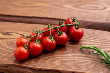 Ahşap arka planda kiraz domatesleri. Taze domates dalı. Vejetaryen yemeği..