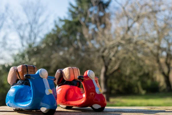 緑の芝生の背景に木製の表面に2つのおもちゃのスクーター 旅行の概念 — ストック写真
