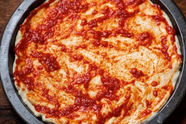 Pizza pişirme. Domates sosuna bulanmış hamur..