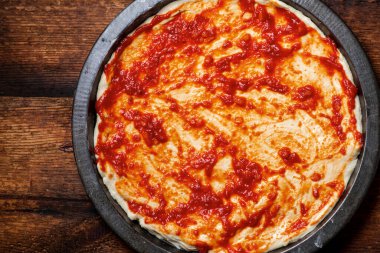 Pizza pişirme. Domates sosuna bulanmış hamur..