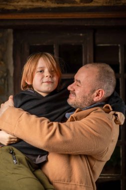 Genç oğlunu kucaklayan bir adam. Babalar Günü, uzun zamandır beklenen toplantı. Orta yaşlı bir adam ve dokuz yaşında bir çocuk..