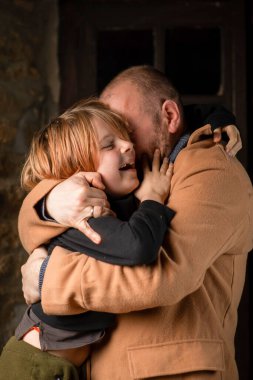 Genç oğlunu kucaklayan bir adam. Babalar Günü, uzun zamandır beklenen toplantı. Orta yaşlı bir adam ve dokuz yaşında bir çocuk..