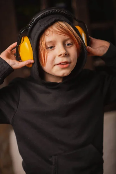 Ένα Νεαρό Αγόρι Μεγάλα Ακουστικά Ενάντια Στο Θόρυβο Σκοτεινό Φόντο — Φωτογραφία Αρχείου