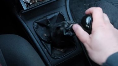 Bir adamın eli eski bir arabanın vites kolunu çeker. Araç arızası. Elle Aktarım.