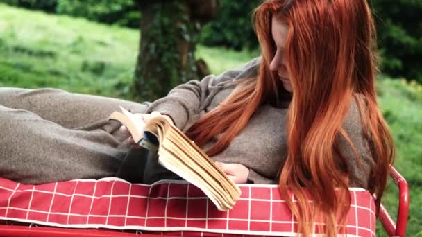 Eine Frau Liegt Draußen Und Liest Ein Buch Eine Junge — Stockvideo