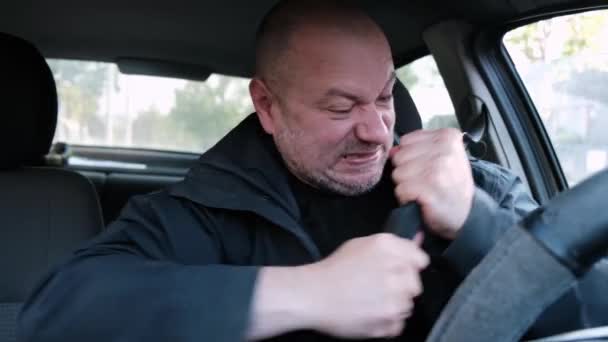 車の中でシートベルトが嫌い 男はシートベルトの上で半狂乱になる 運転中の運転安全 — ストック動画