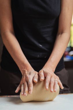 Tanınmayan kadın hamuru kesme tahtasında hazırlıyor. Ekmek ve pizza için hamur hazırlığı.