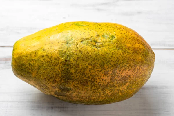 Hela Papaya Vit Trä Bakgrund Grön Gul Ful Frukt — Stockfoto