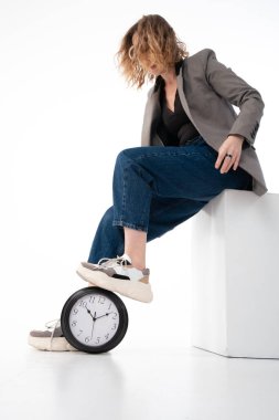 Teslim tarihi konsepti, zaman yönetimi. Kadın büyük saate basmış. Beyaz arkaplanda.