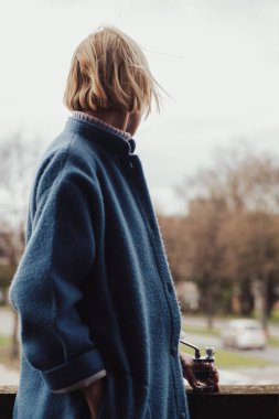 Esrar içmek için kadın ve cihaz. Tanımlanamayan bir kadın balkonda elinde küçük bir nargileyle bekliyor. Marihuana içiyor..