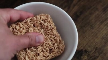 Hazır şehriye pişiriyorum. Erkek eli tabakta vermicelli kırar..