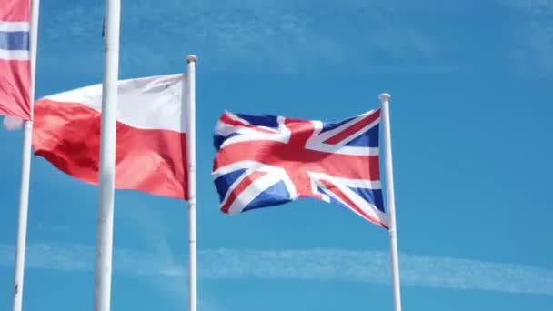 Flaga Wielkiej Brytanii Flaga Indonezji Powiewają Wietrze Przeciwko Błękitnemu Niebu — Wideo stockowe