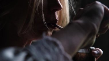 Bir kadın cihaz kullanarak marihuana içiyor. Esrar kullanımı.